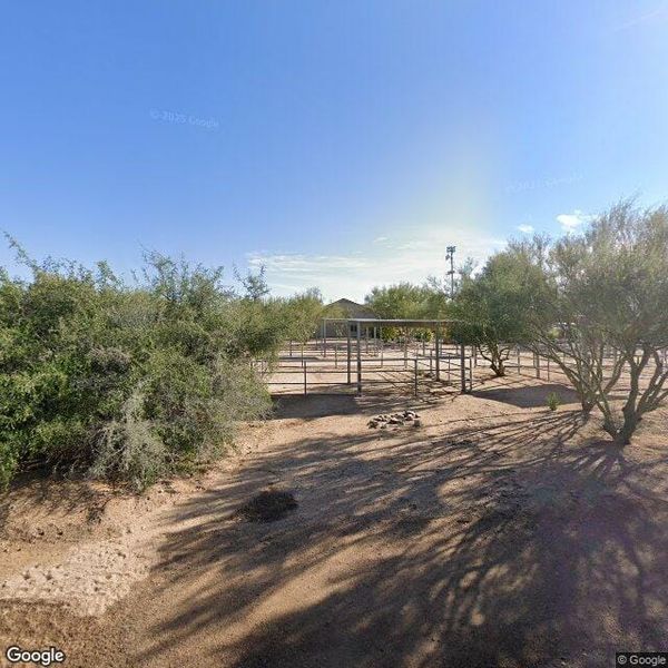view of a desert residential lot in the Scottsdale foothills at midday, rocky terrain and sparse desert vegetation, no people