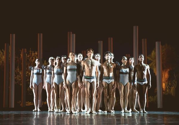 Empty ballet studio interior at dusk, barres along mirrored walls, late afternoon light through tall windows, no people