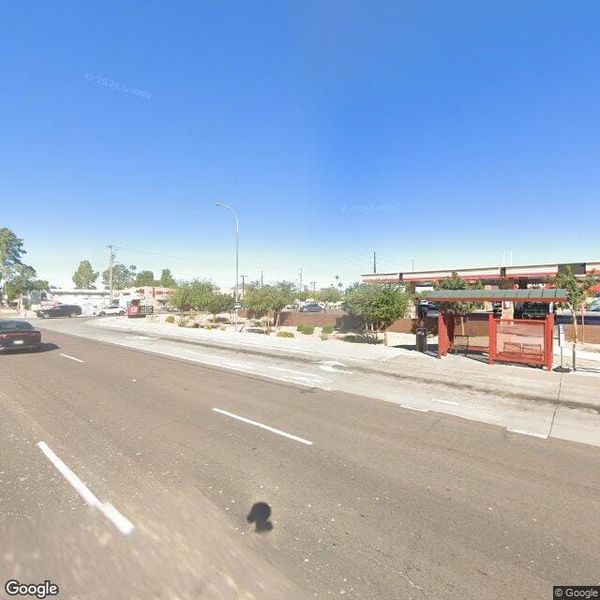 of a desert highway stretching toward a mountain horizon under a hazy summer sky, no vehicles, no people, no signage