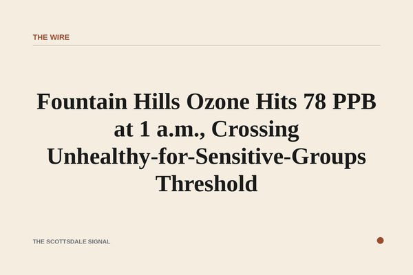 of a hazy desert sky at night over a low-rise suburban landscape, faint orange glow on the horizon, no people