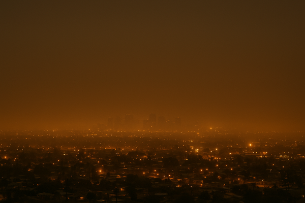 of a hazy Phoenix valley skyline at night, orange glow from city lights diffused through smoggy air, no people, no text