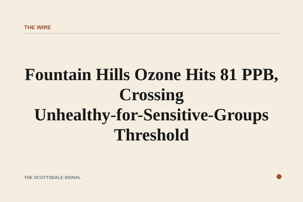 of a hazy desert sky over low hills at dusk, warm orange light diffused through thick air, no people