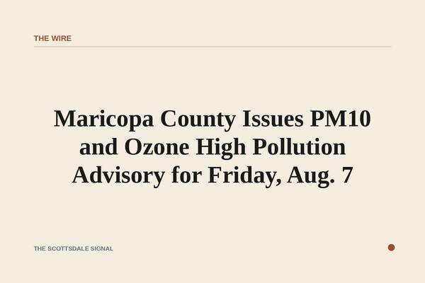 of a hazy Phoenix-area skyline at midday, brown particulate haze visible in the air, desert mountains barely visible in the b