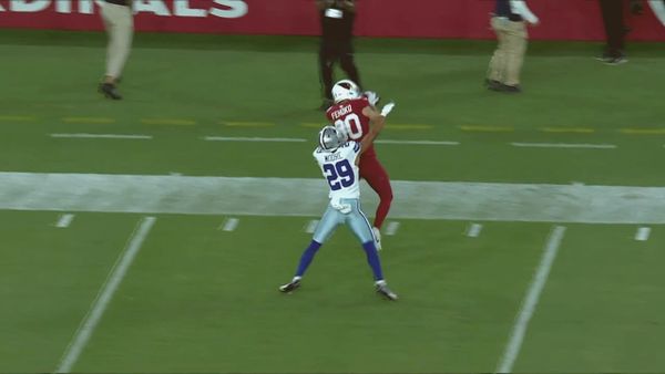 of a football mid-air after being blocked on a special teams play, desert stadium lights in the background, no people visible