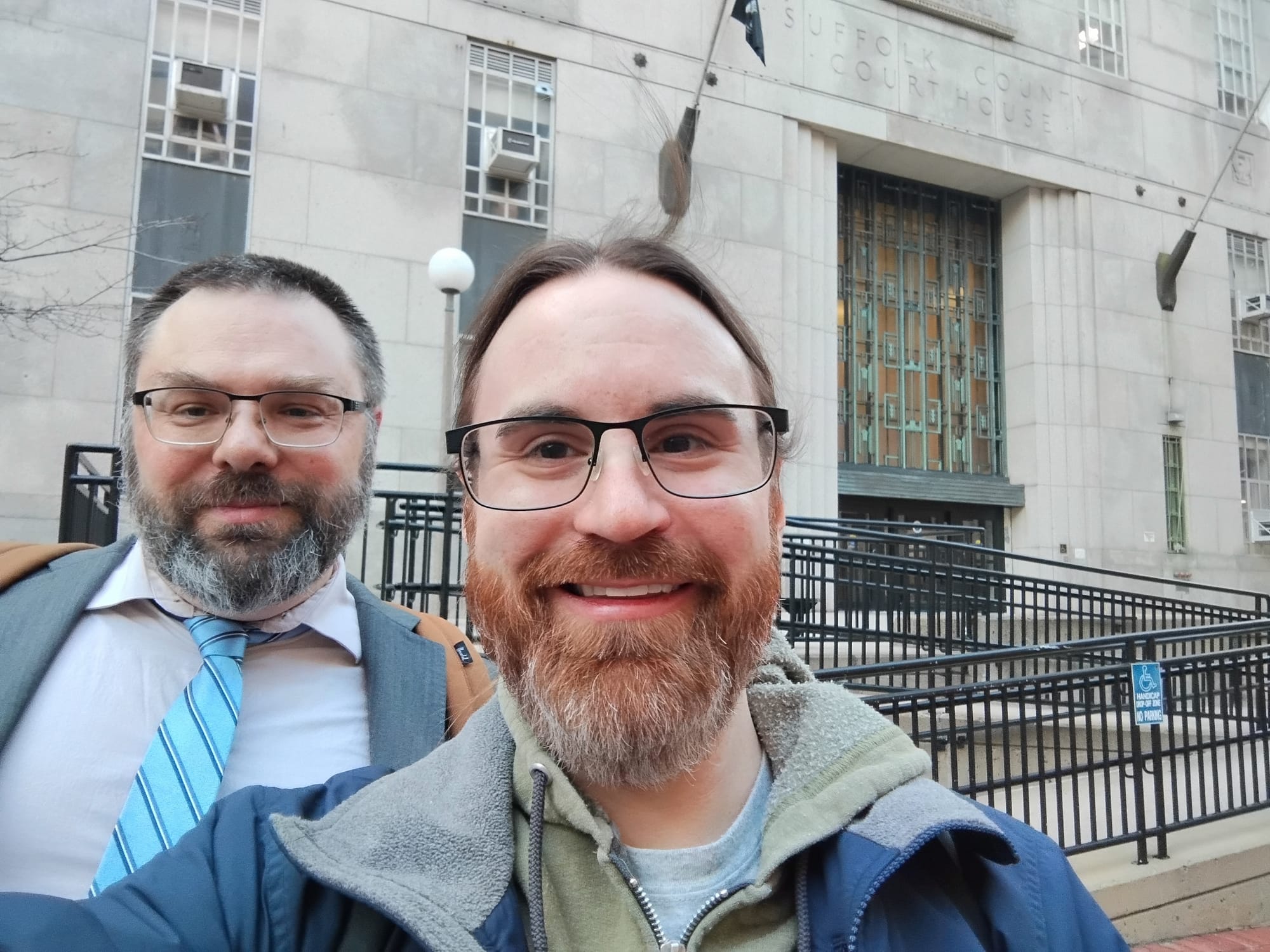 Two handsome dudes smiling outside Suffolk County Superior Court in Boston after a job well done.