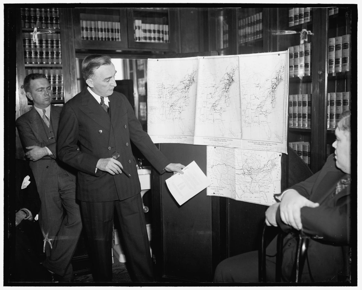 Senator Joseph O'Mahoney with a few transportation maps.  