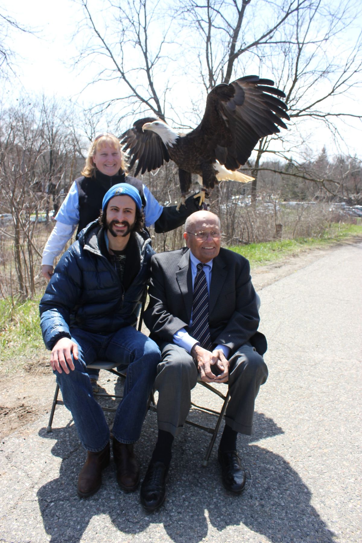 Congressman John Dingell sets in the foreground, a bald eagle is in the background. 