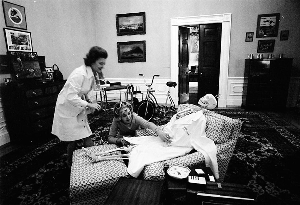 First Lady Betty Ford and her Secretary Nancy Howe lay a skeleton out in President Ford’s chair for Halloween. 