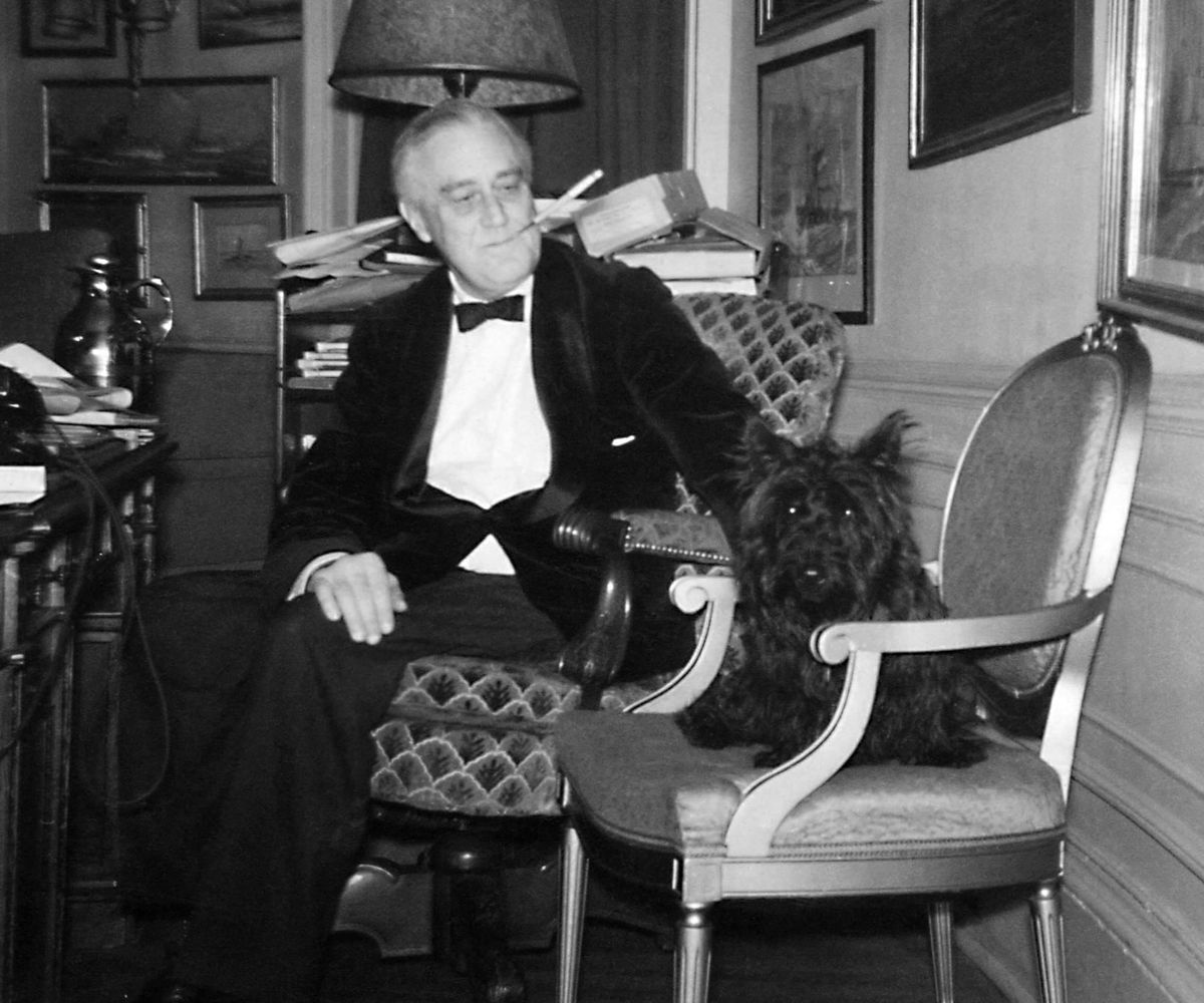 President Roosevelt sits next to his small dog Fala. 