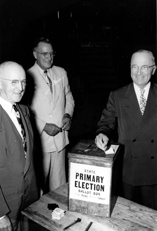 President Truman dropping his ballot in a box that reads, “State Primary Election Ballot Box."