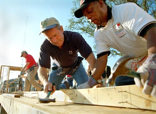 President Bush bangs a hammer on a build for Habitat for Humanity 