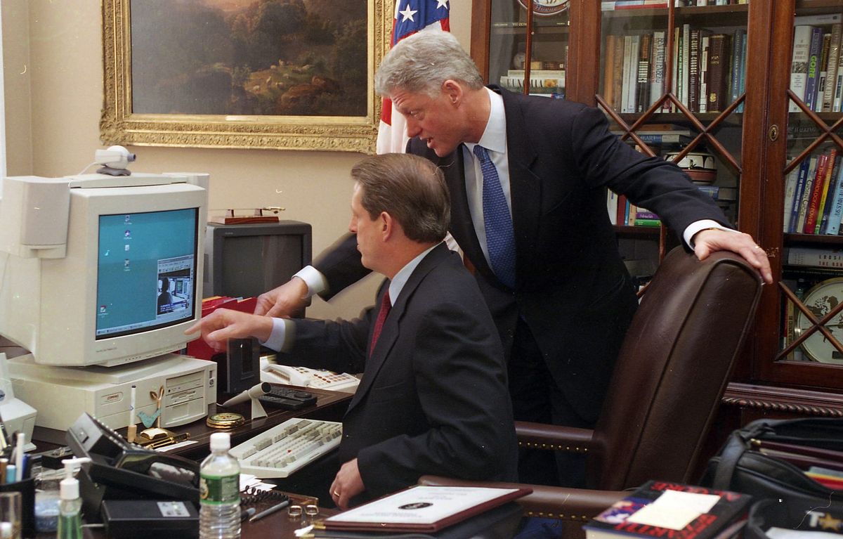 President Clinton points to a computer while Vice President Gore looks on. 