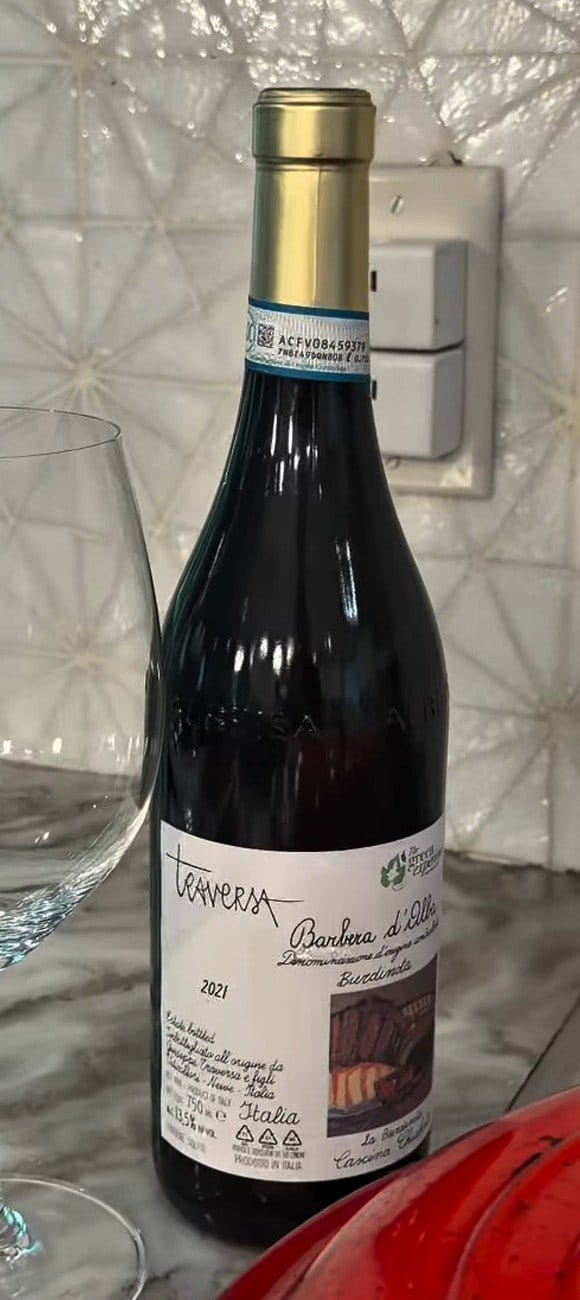 Bottle of Traversa Barbera d'Alba Burdinota 2021, front label, beside an empty wine glass