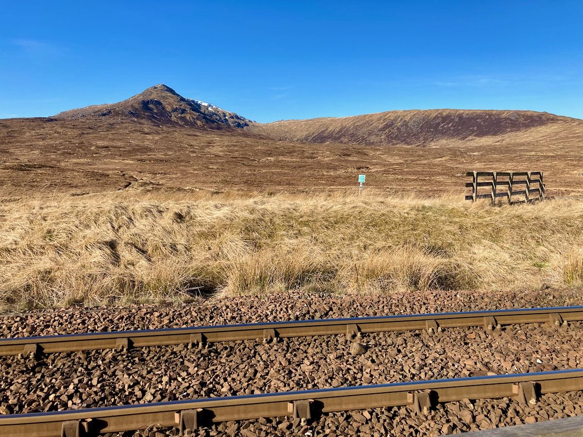 Im Vordergrund ein Gleis, im Hintergrund ein Berg