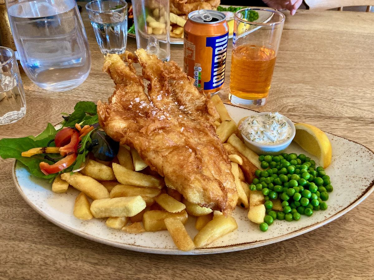 Ein Teller Fish and chips und im Hintergrund Getränke
