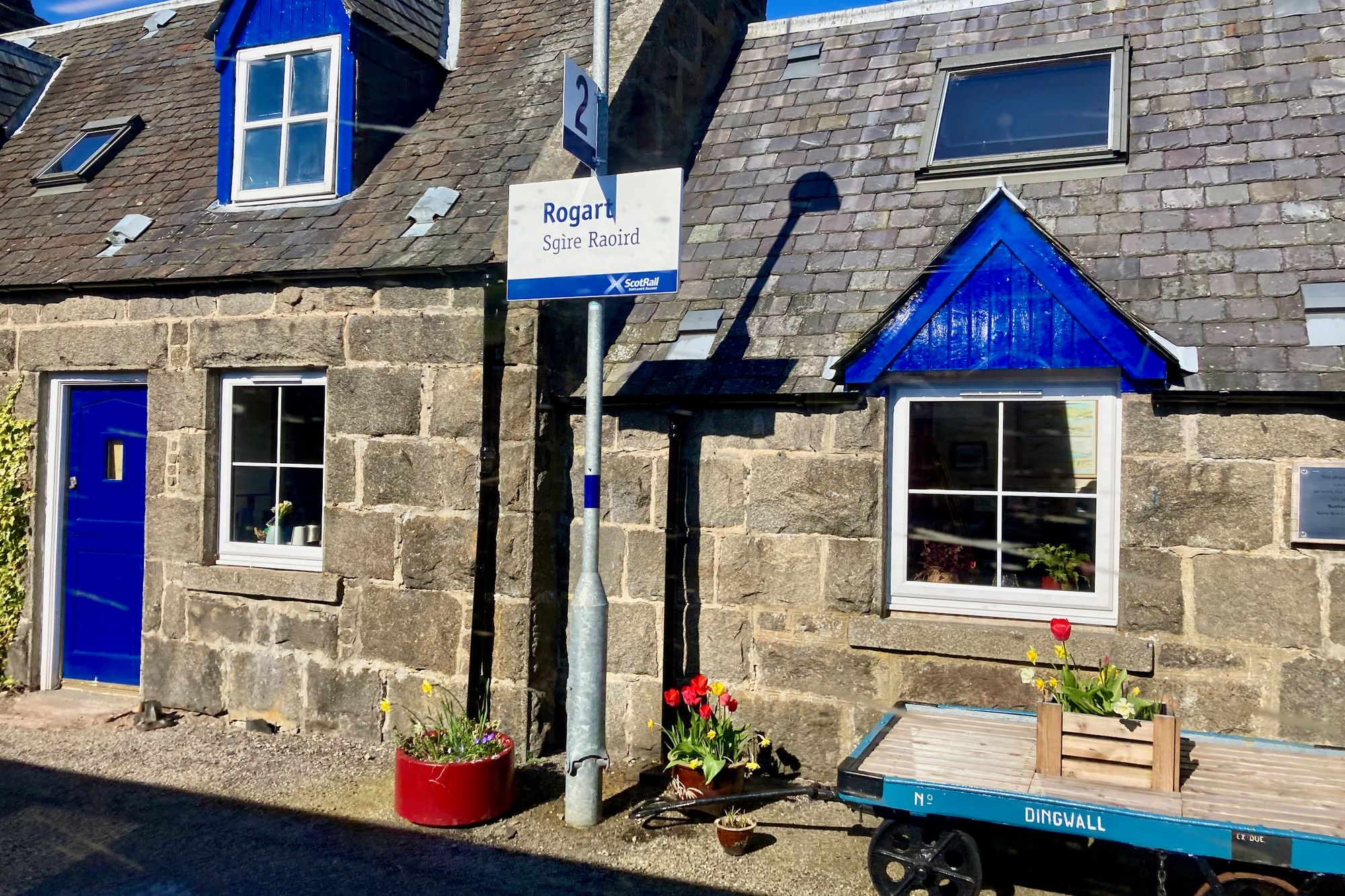 Bild: Bahnhof Rogart mit Blumen und einem Handwagen