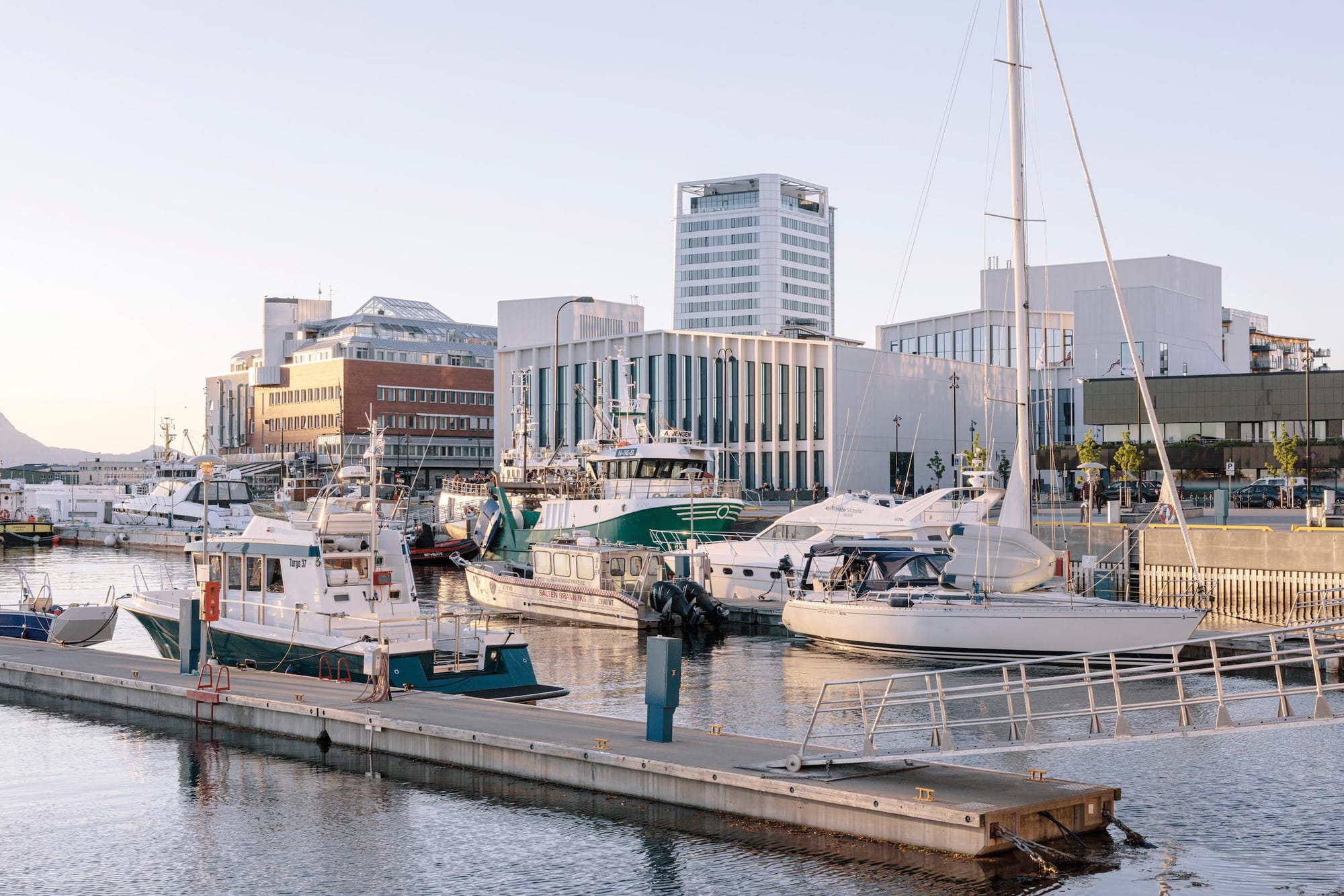 Stadtaufnahme aus Bodø mit Wasser und Booten im Vordergrund