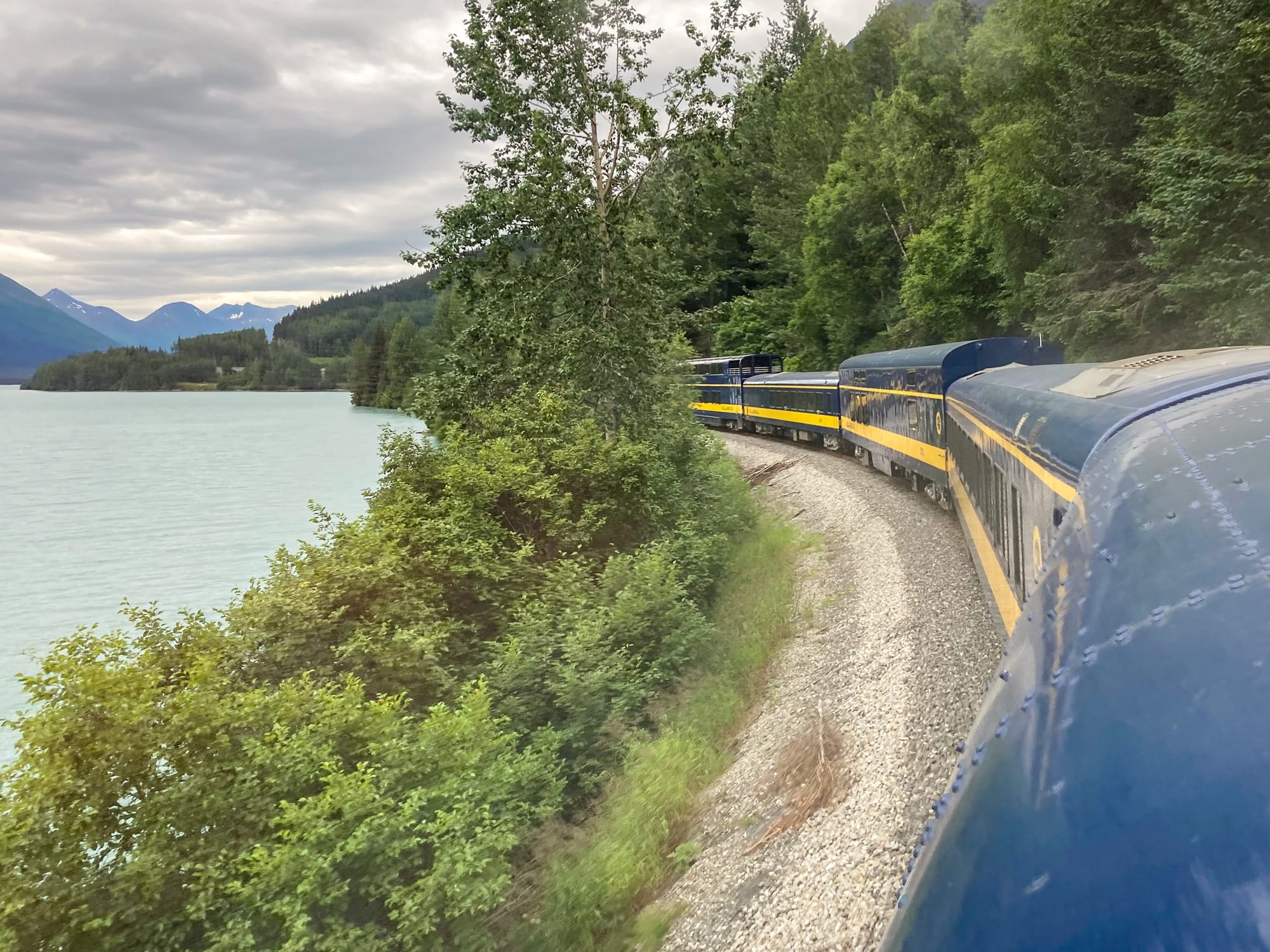 Ein blau-gelber Zug in Alaska legt sich in die Kurve