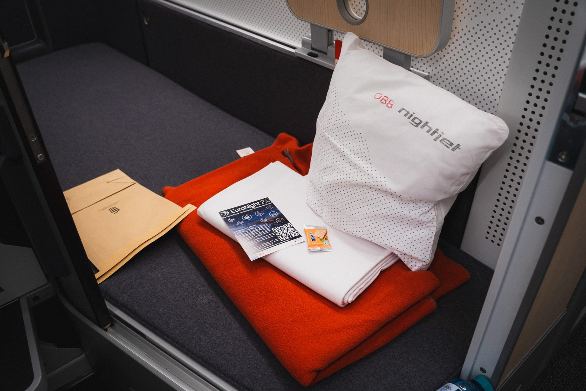 Decke, Bettlaken und Kissen liegen auf dem Bett in einer Mini Cabin