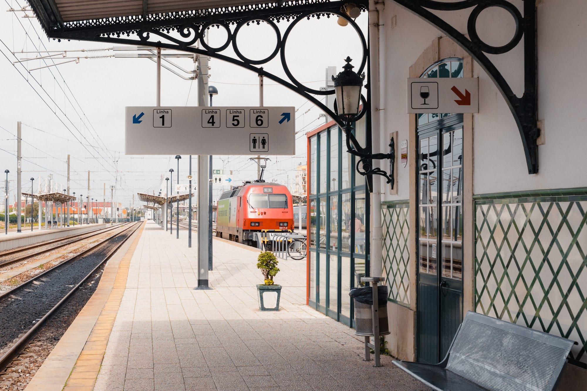 Bahnsteig am Bahnhof Faro mit roter Lok im Hintergrund