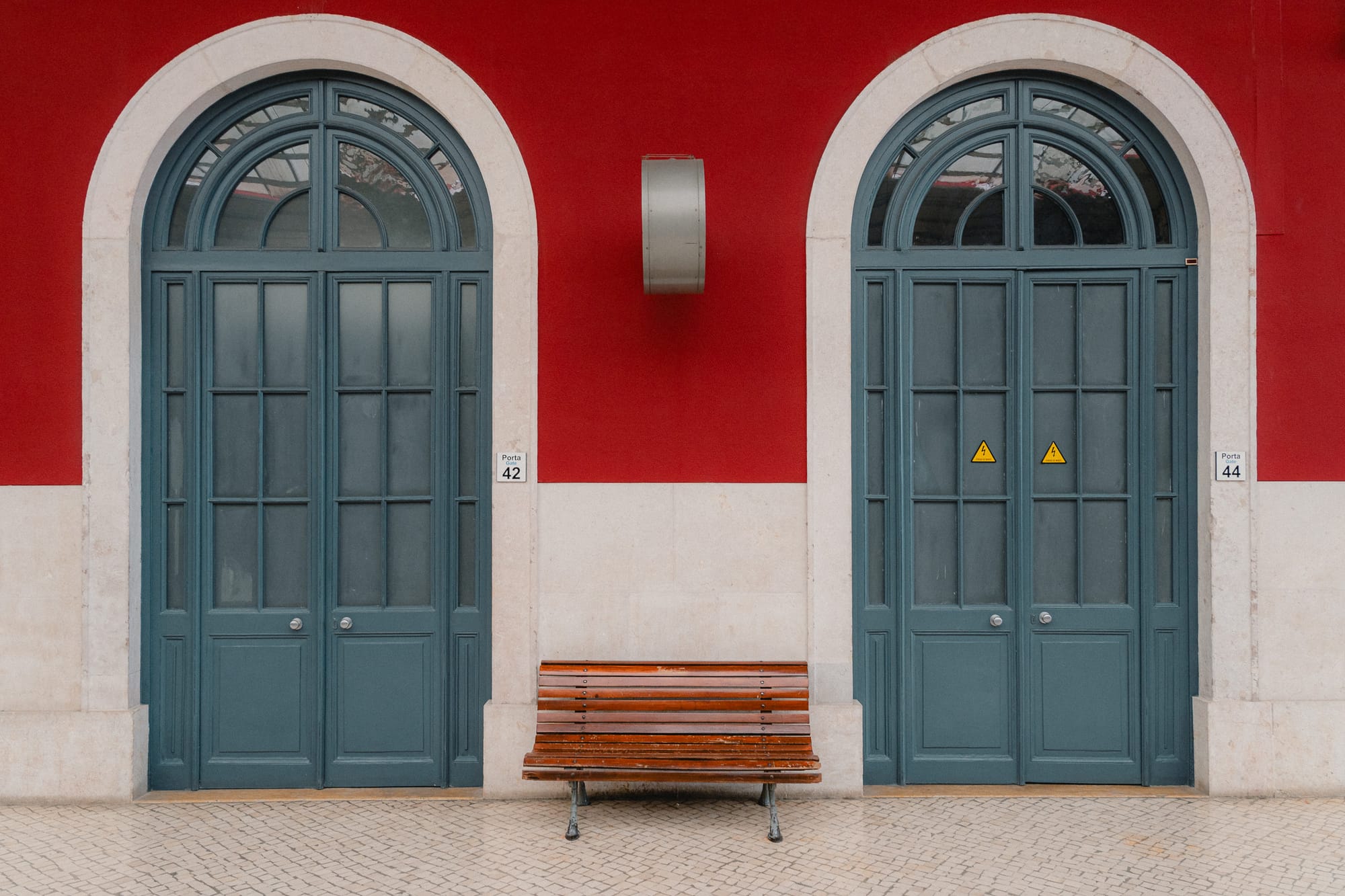 Bank und zwei Tore an roter Wand