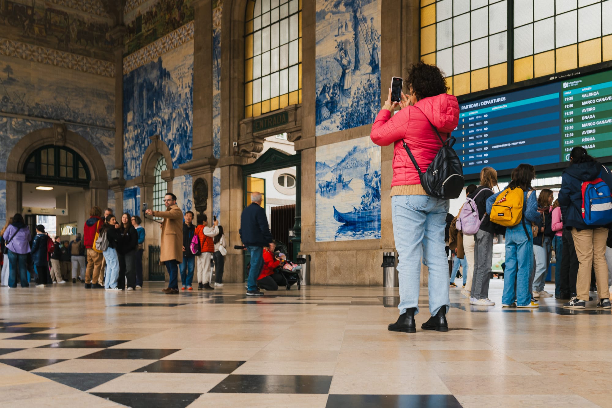 Frau steht im Bahnhof Porto Sao Bento und fotografiert