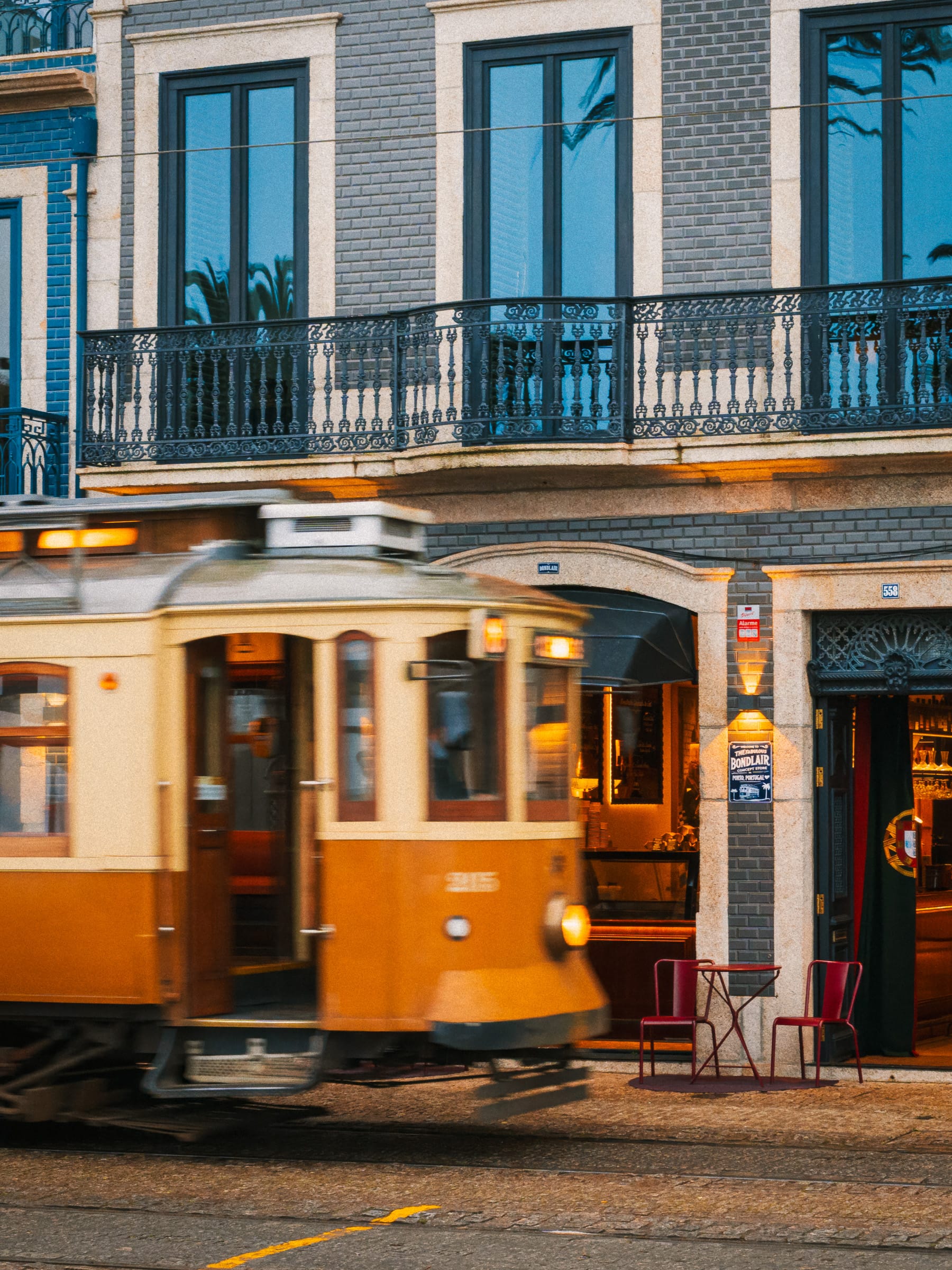 Straßenbahn von Porto vor einem Straßencafé