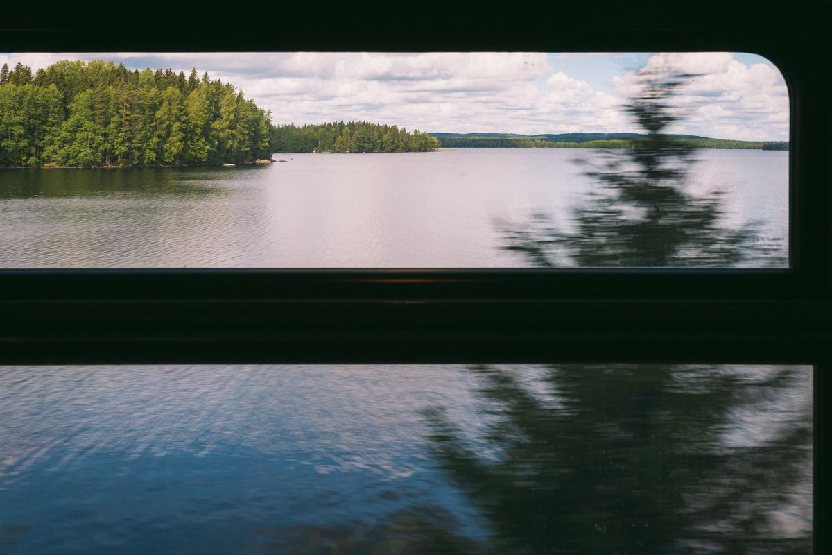 Blick durch das Zugfenster auf einen See