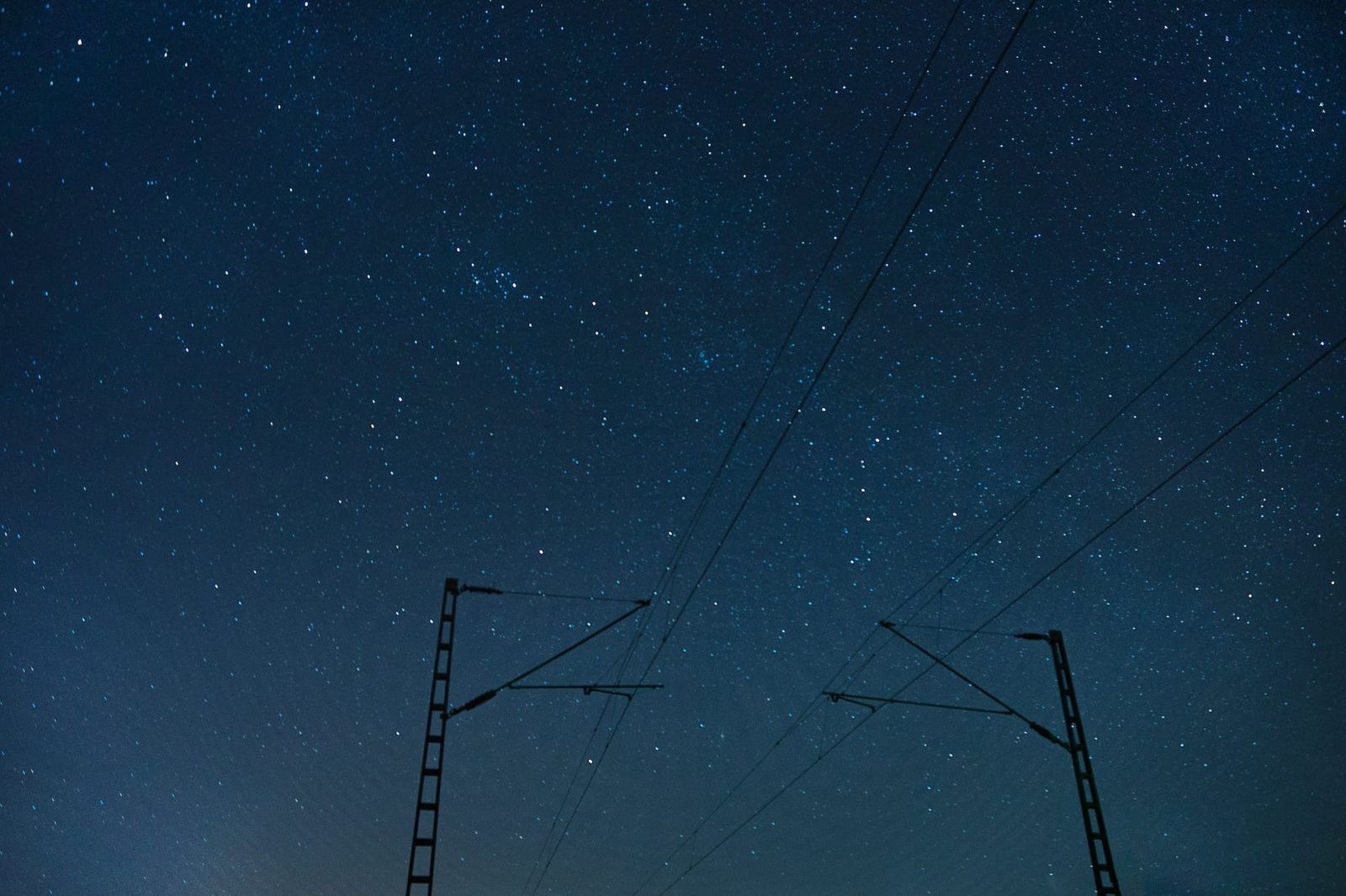 Nachtzug 2024: Oberleitungsmasten vor Nachthimmel