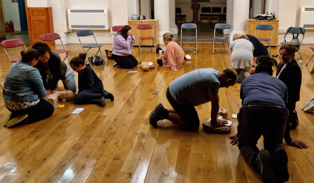 Members of the public practising CPR and AED use during a free community training session.