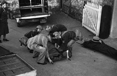 Black-and-white photograph showing civilian first aiders attending to an injured person during the Second World War