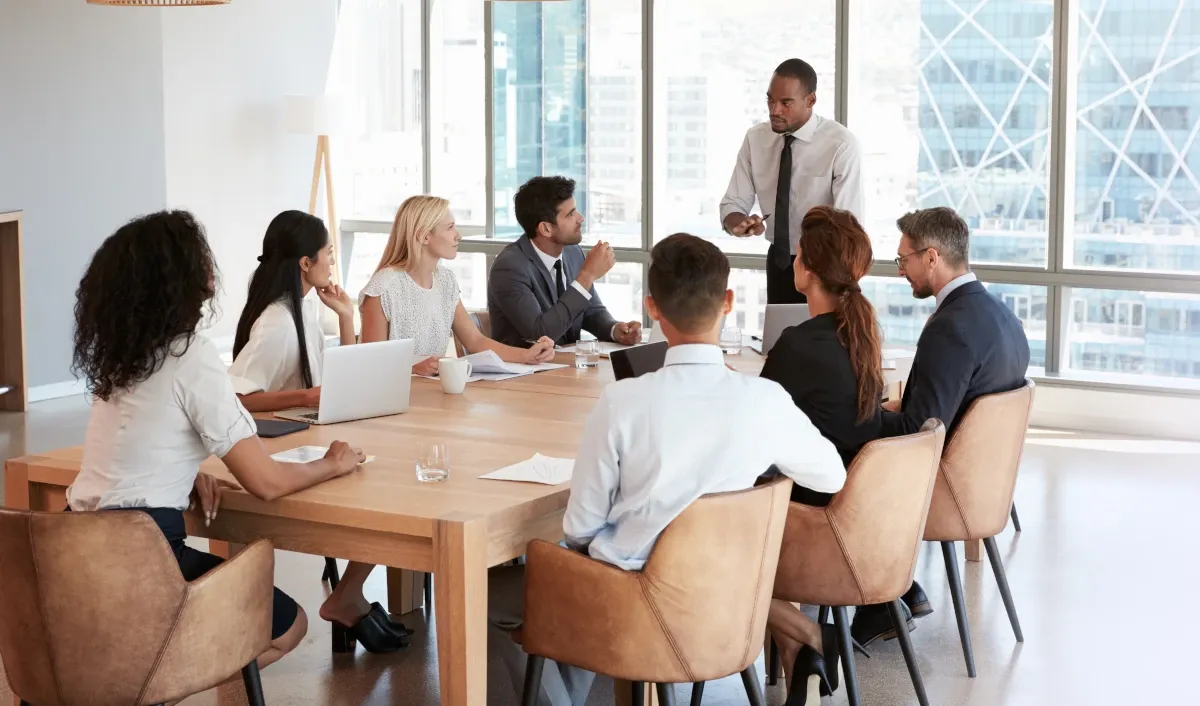 Team meeting in a modern office with a manager leading a discussion.