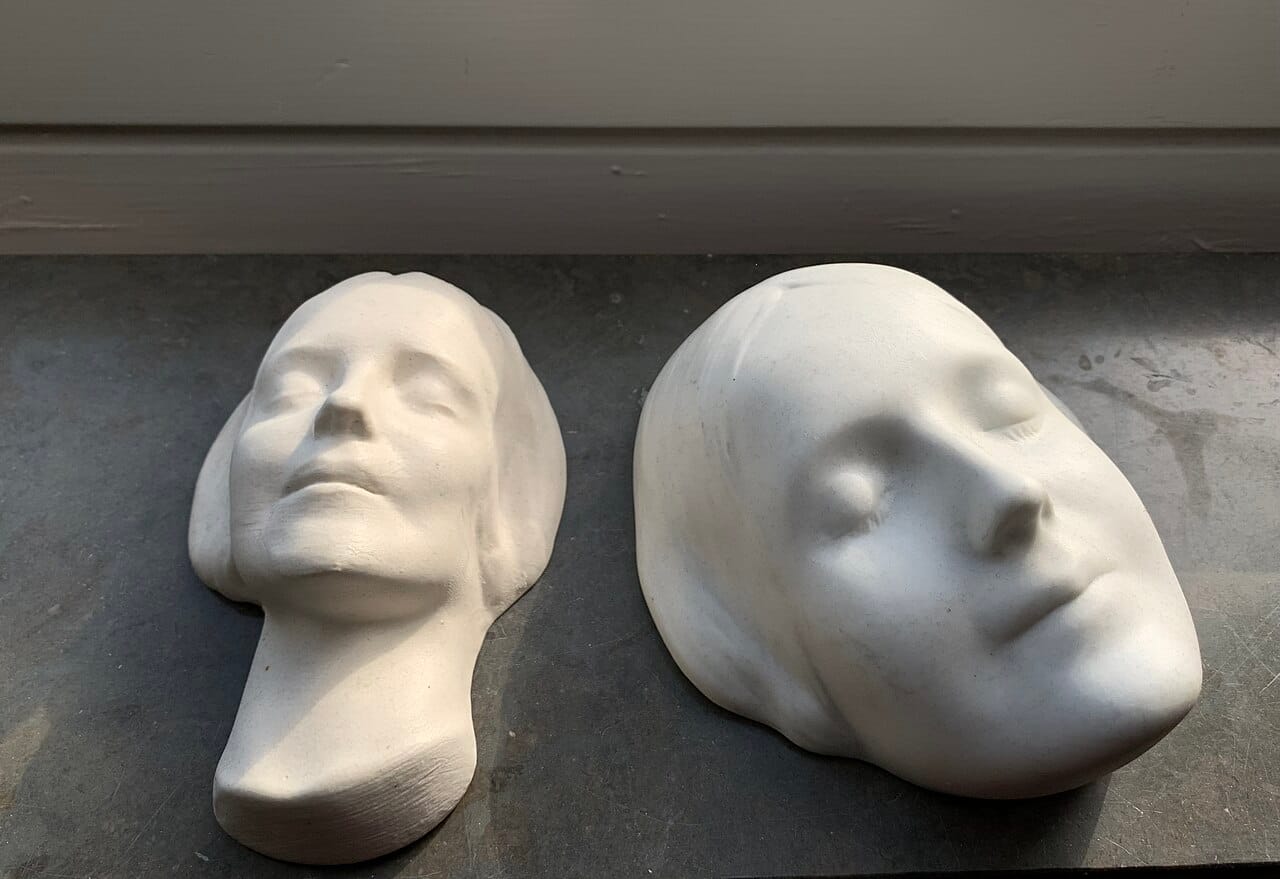 Two plaster death masks of L'Inconnue de la Seine, the unidentified young woman whose face became the model for Resusci Anne CPR training manikins.