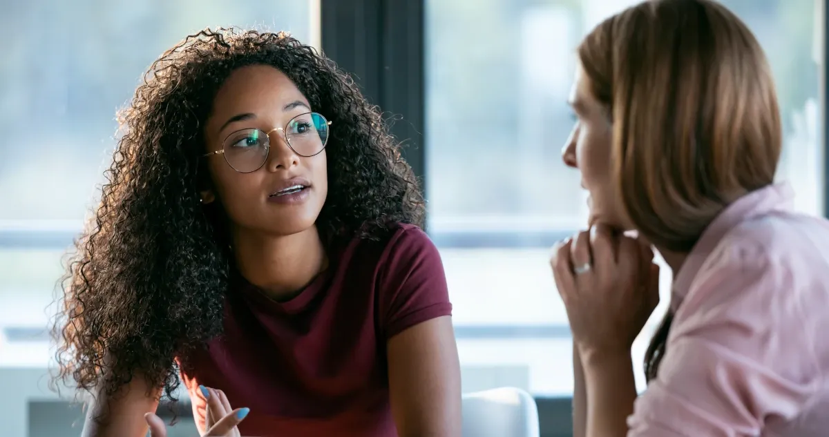 Two colleagues having a focused conversation in an office
