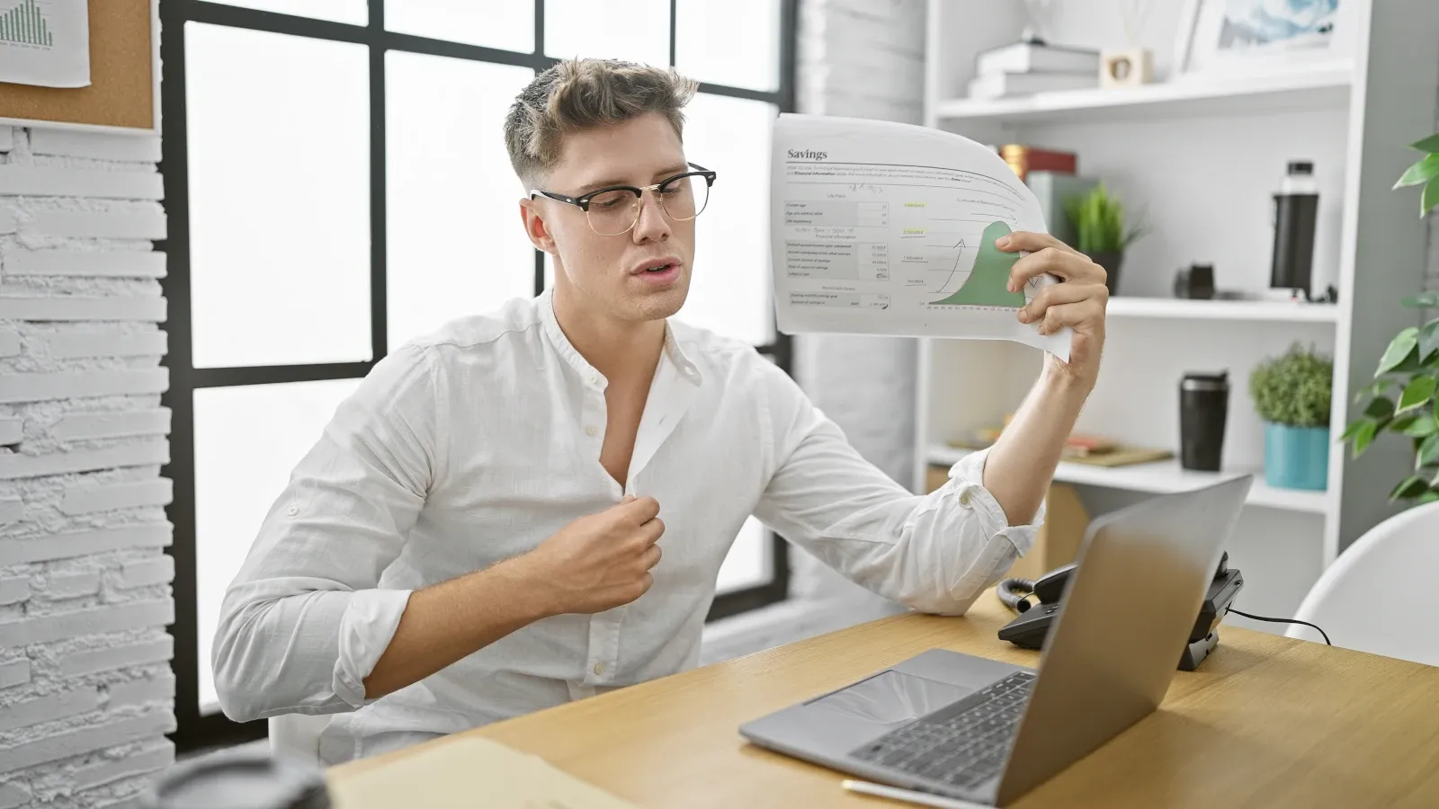 Office employee struggling with high indoor temperatures while working at a desk