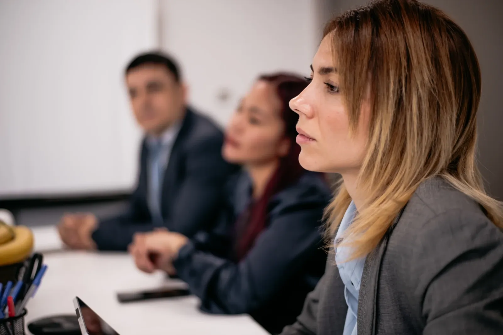 A quiet employee sitting apart during a workplace meeting.