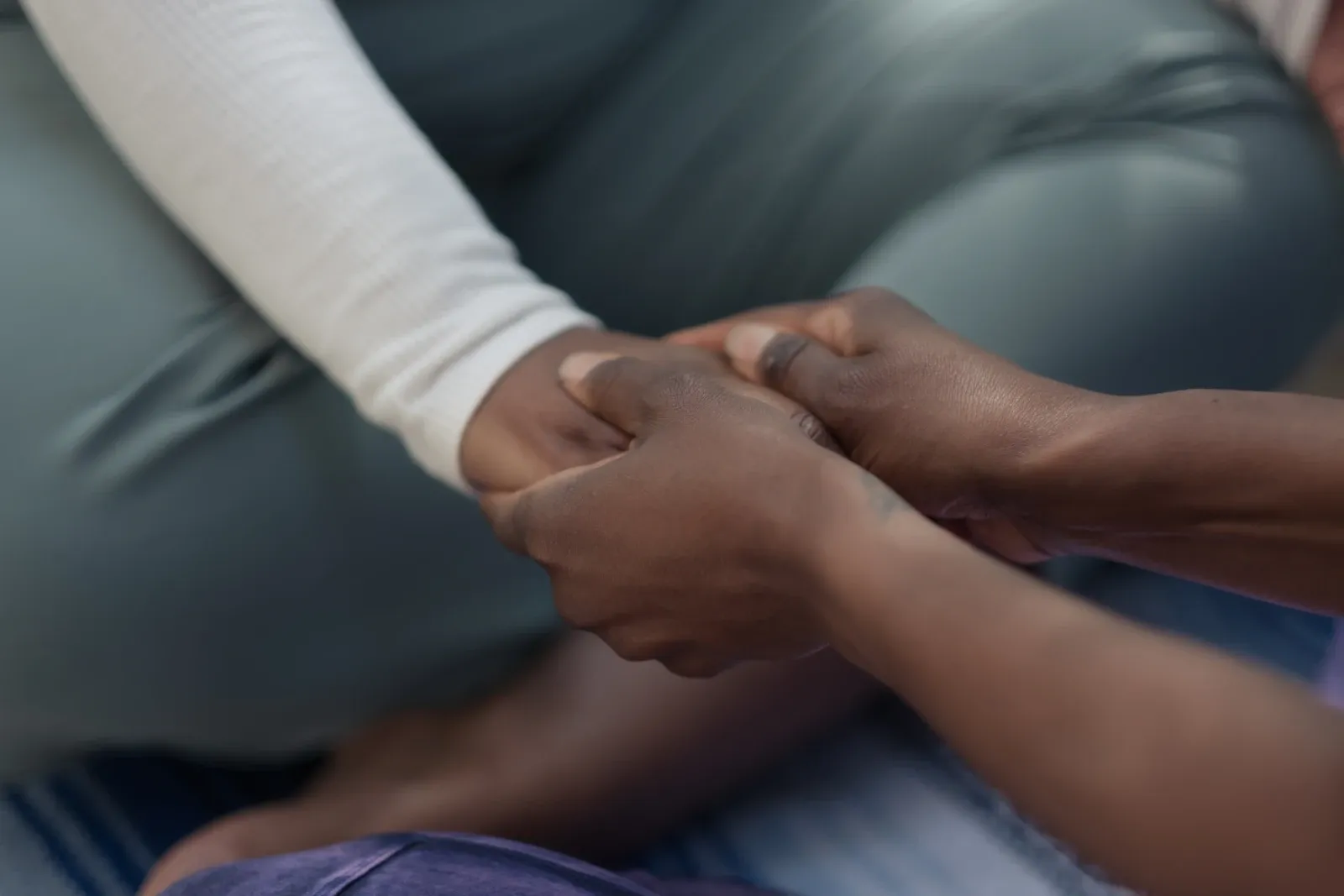 One person holding another person’s hands in support.
