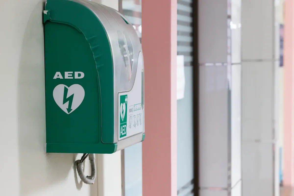 Wall-mounted AED in a workplace corridor, positioned for quick access in an emergency