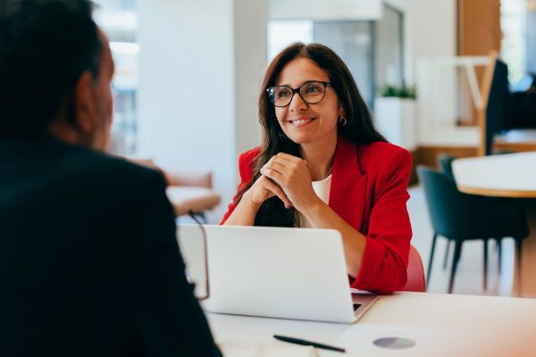 Two colleagues having a professional conversation in a workplace setting