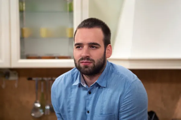 A man sitting quietly at home, looking thoughtful and emotionally distant, illustrating the often hidden experience of loneliness.