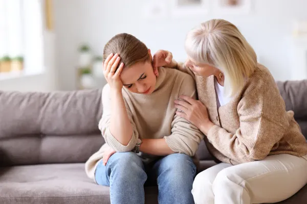 Woman comforting a distressed younger family member at home.
