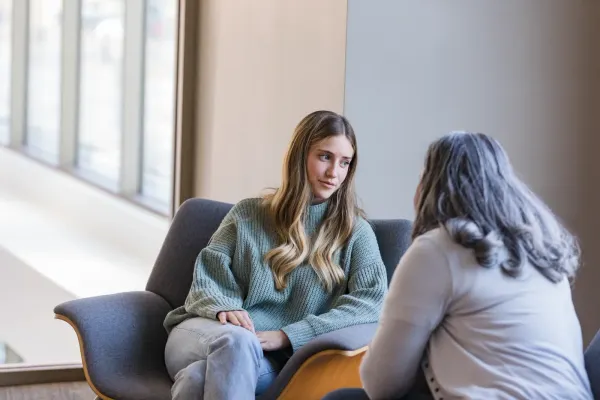Two women having a calm and supportive conversation in a bright room