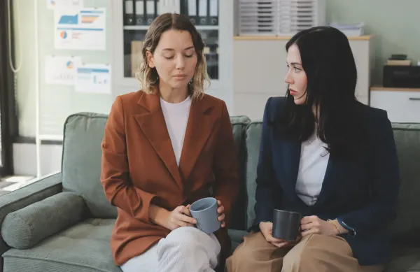 Two colleagues having a serious and supportive conversation in a workplace