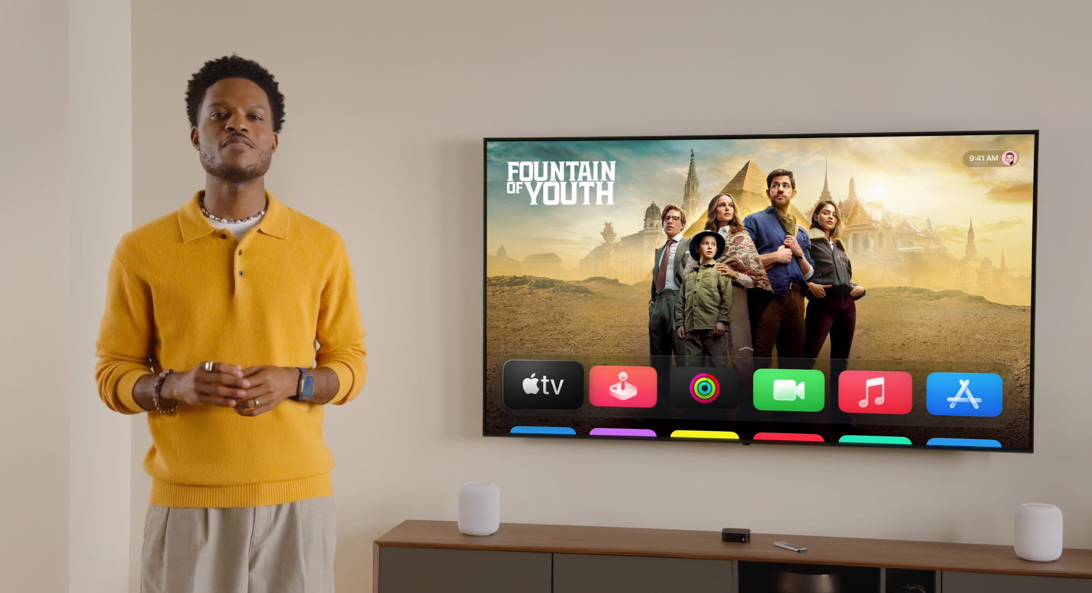 Screenshot from Apple's keynote showing a person talking with tvOS displaying "Fountain of Youth" behind him.