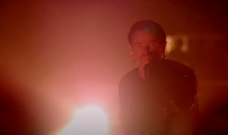 Bono holding a spotlight from the Bullet the Blue Sky live in Boston 2001 video