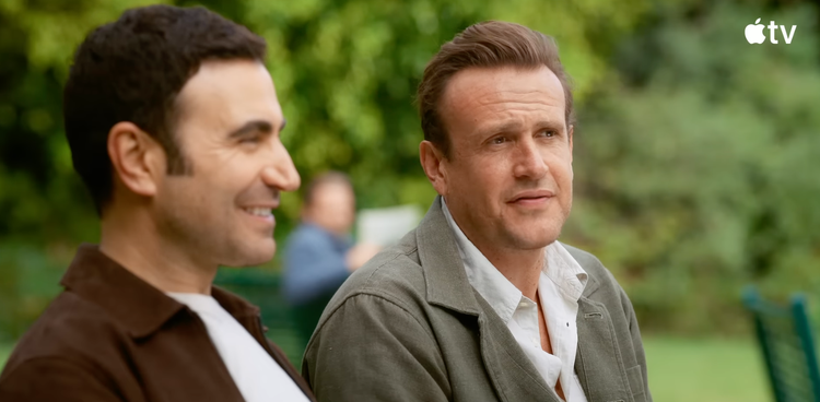 Screenshot from Shrinking season 3 trailer showing Brett Goldstein and Jason Segal sitting on a bench