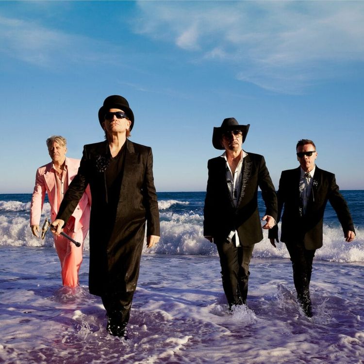 U2's band members walking out of the ocean in a promotional photo for their new album