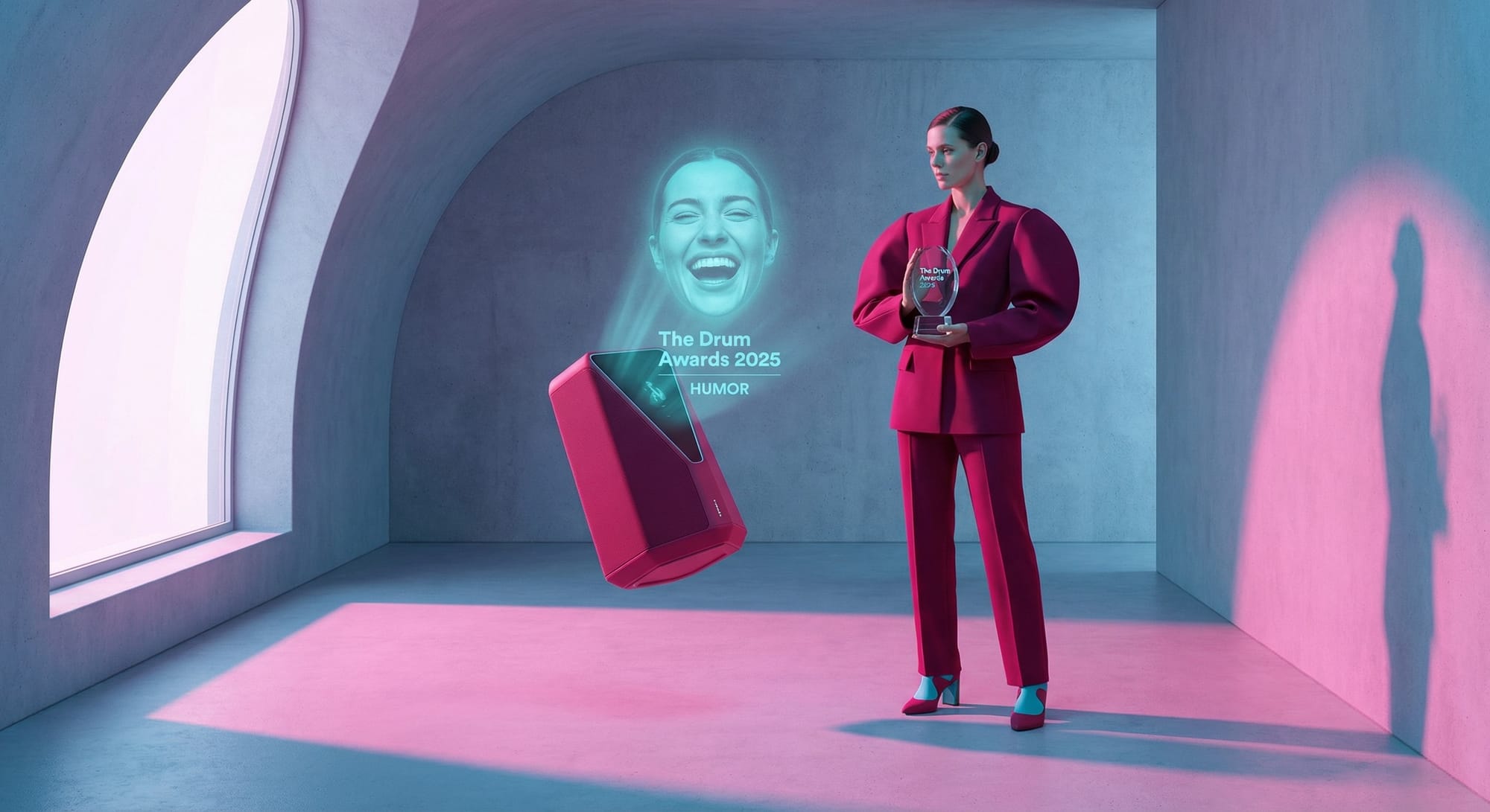 Vrouw in fuchsia pak houdt award vast bij holografische projectie, The Drum Awards 2025 Humor categorie