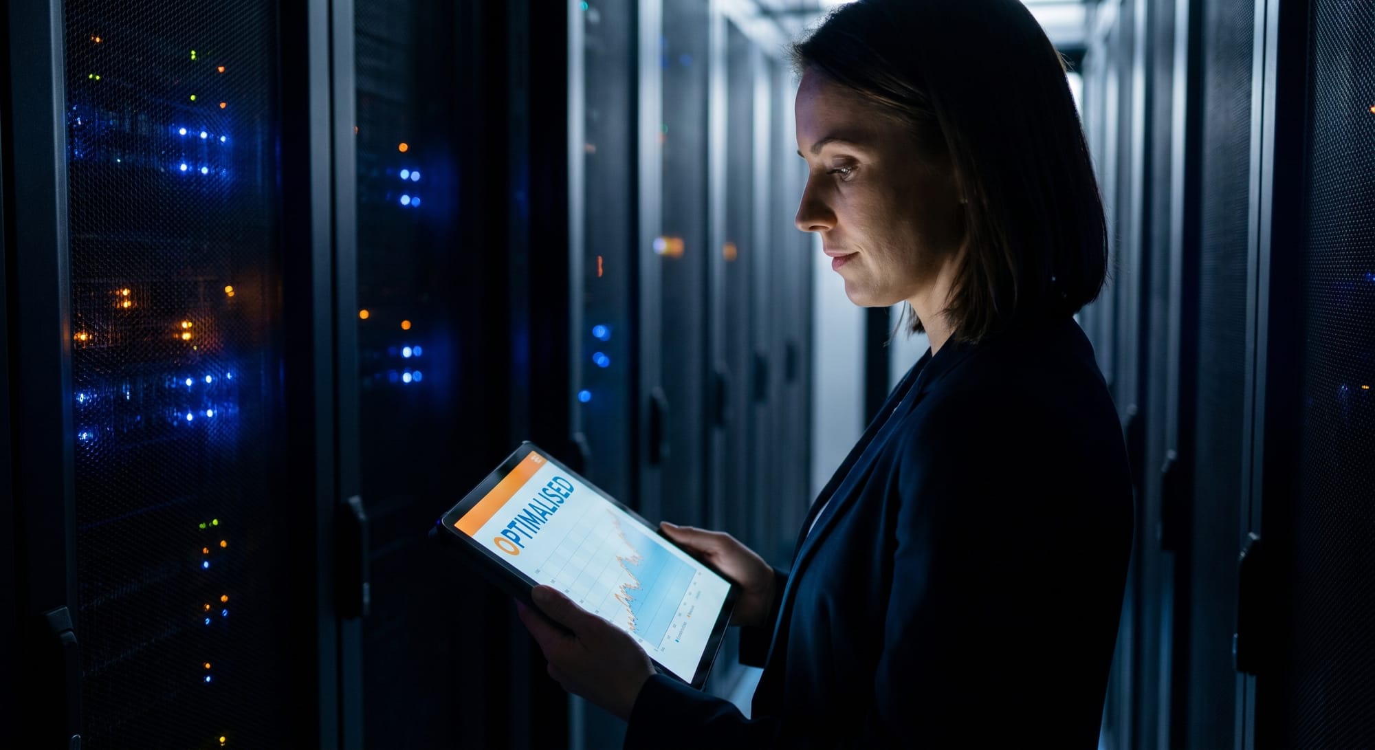 Vrouw met tablet in serverruimte met blauwe en oranje ledlampjes op achtergrond