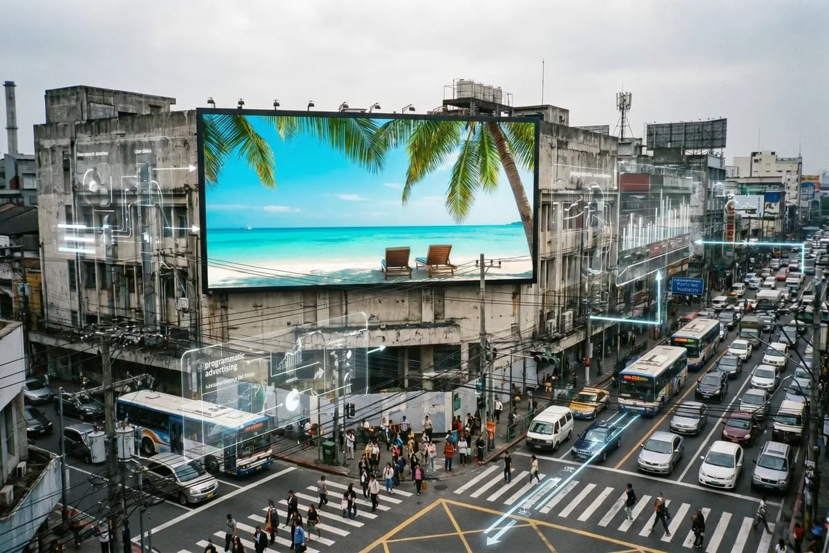 Groot reclamebord met tropisch strand en palmboom hangt boven grijze stedelijke straat met druk verkeer